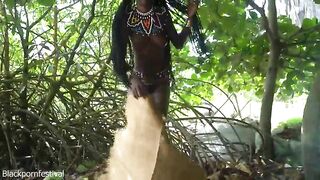 Glamorous tribe angel making traditional jewelery next to a firecamp