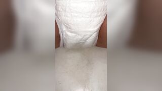 Playgirl fills up diaper with piddle until it overflows out the side